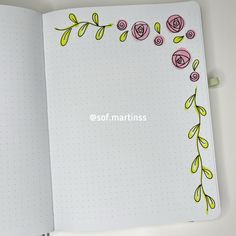 an open notebook with flowers drawn on the pages and dotted paper in the bottom corner