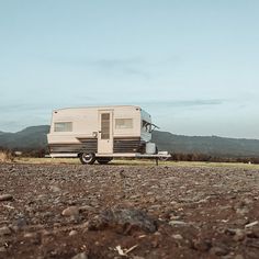 an rv parked on the side of a dirt road