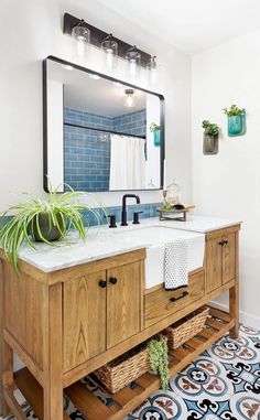 a bathroom with a sink, mirror and plants on the counter top in front of it