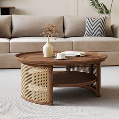 a coffee table with a vase on it in front of a couch and rugs