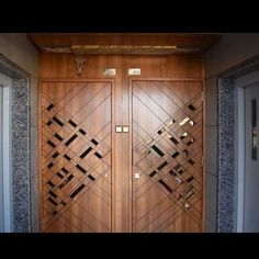 two wooden doors with decorative designs on the front and side panels, in an entry way