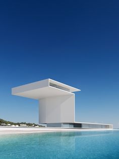 a white building sitting on top of a body of water