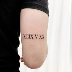 a woman's arm with roman numerals tattooed on the back of it