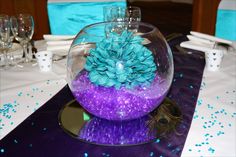 a purple and blue centerpiece in a glass bowl