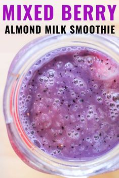 a close up of a drink in a mason jar with the words mixed berry almond milk smoothie