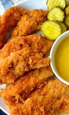 fried chicken with dipping sauce and pickles on the side