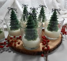 small christmas trees in glass cups on a wooden tray