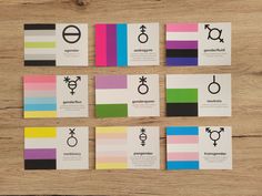 six business cards with symbols on them sitting next to each other in front of a wooden table