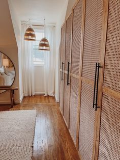 a bedroom with wooden closets and white curtains