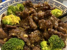 beef and broccoli in a bowl with chopsticks on the side, ready to be eaten