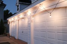 a white garage with christmas lights on the side