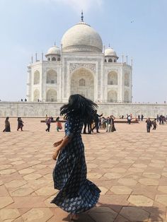 a woman in a blue dress is walking towards the tajwa