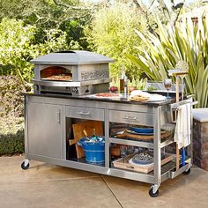 an outdoor bbq grill with food and drinks on the outside patio, next to a potted plant