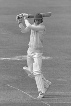 a black and white photo of a man holding a bat