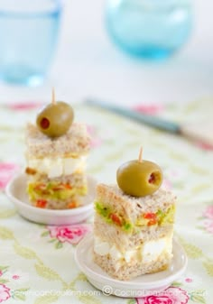 small sandwiches with olives and tomatoes on a white plate