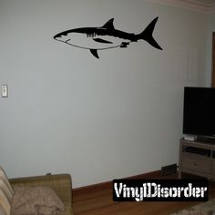 a shark decal on the wall of a living room in front of a flat screen tv