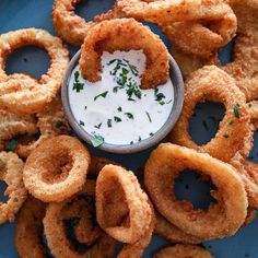 fried onion rings with ranch dip on a blue plate, ready to be used as appetizer