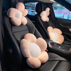 the interior of a car with two flower shaped pillows on the front and back seats