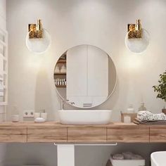 a bathroom with two round mirrors above the sink and white fixtures on the countertop