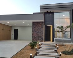 a modern house with stone steps leading to the front door