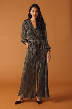 A woven micro pleated jumpsuit featuring surplice neckline, long sleeve with smocked cuff, elasticized waist, self sash tie and wide leg Details: Self : 100% Polyester Size & Fit - Model is 5`8" And Wearing Size Small- Measurements Taken From Size Small- Approx. Length: 60" Belted V-neck Jumpsuits And Rompers For Fall, Party Long Sleeve Jumpsuit With Tie Waist, Elegant Fall Jumpsuits And Rompers With Tie Waist, Elegant Long Sleeve Jumpsuits And Rompers With Tie Waist, Chic Tie Waist Jumpsuits And Rompers For Fall, Chic Jumpsuits And Rompers With Tie Waist For Fall, Long Sleeve Jumpsuits For Date Night In Fall, Spring Long Sleeve Jumpsuits With Elastic Waistband, Spring Long Sleeve Jumpsuits And Rompers With Elastic Waistband