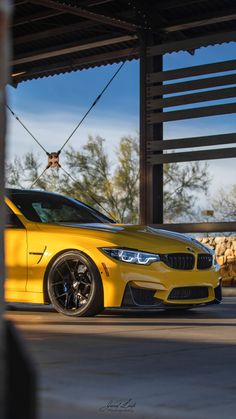 a yellow sports car parked in front of a building