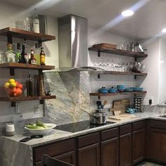 the kitchen is clean and ready to be used for cooking or baking, with many shelves on the wall