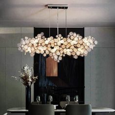 a modern chandelier hanging over a dining room table