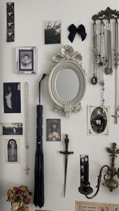 a white wall covered in lots of different types of jewelry and mirrors on it's walls