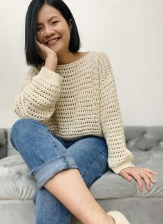 a woman sitting on top of a couch smiling