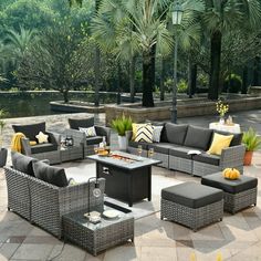 an outdoor living room with grey wicker furniture and yellow pillows on the couches