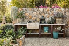 a stone wall with potted plants on it