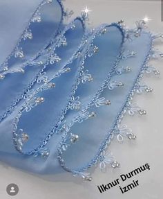 the blue fabric has beading on it and is next to a white table cloth