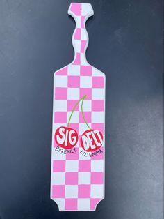 a pink and white gingham bottle shaped sign