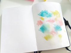 an open notebook with watercolors on it