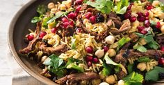 a bowl filled with meat and vegetables on top of a table