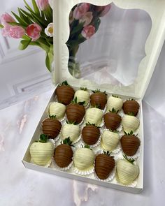 a box filled with chocolate covered strawberries on top of a table