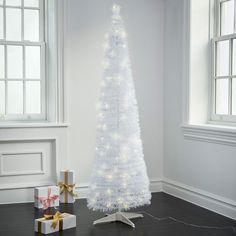 a white christmas tree with lights and presents