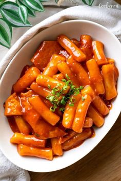 a white bowl filled with carrots covered in sauce