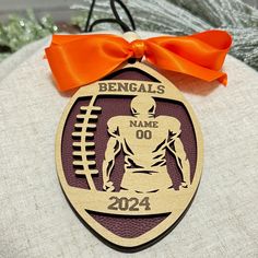 a football ornament with an orange bow on it