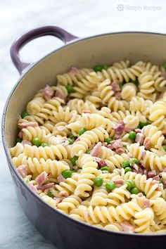 a pot filled with pasta and peas on top of a table