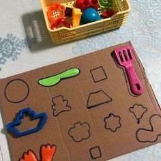 a cardboard box filled with plastic toys on top of a table next to a basket