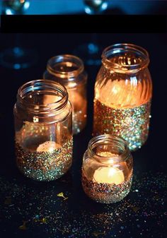 three jars filled with glitter next to each other on a counter top and the words glitter new year's eve written above them