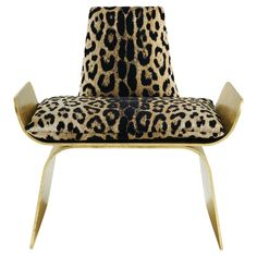 an animal print chair with gold legs and a leopard print upholstered backrest