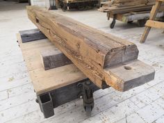 a wooden bench sitting on top of a hard wood floor next to benches and tables