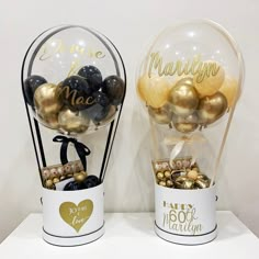 two vases filled with gold and black balloons