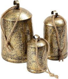 three metal canisters with rope wrapped around the top one has a bell on it