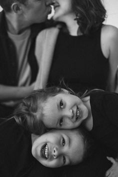 two children are laying on the floor with their mouths open and one child is holding his mother's head