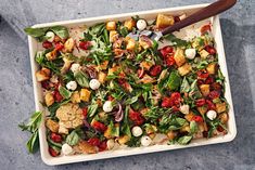 a square white dish filled with salad and dressing