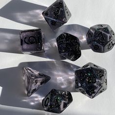 five black and white dice laying on top of each other in the sun with their shadows